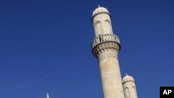 Muslim women enter the mosque in the village of Nardaran, some 35 km (22 miles) north-east of Baku October 28, 2010. Many of Nardaran's dead were interred beneath concrete when the grounds of its vast sandstone mosque were expanded through the cemetery to