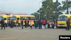 Bölge sakinleri, etnik Ermeniler'in yaşadığı Dağlık Karabağ'dan ayrılmadan önce bölge başkenti Hankendi'nin (Stepanakert) merkezinde otobüslerin yanında toplanıyor- 25 Eylül 2023