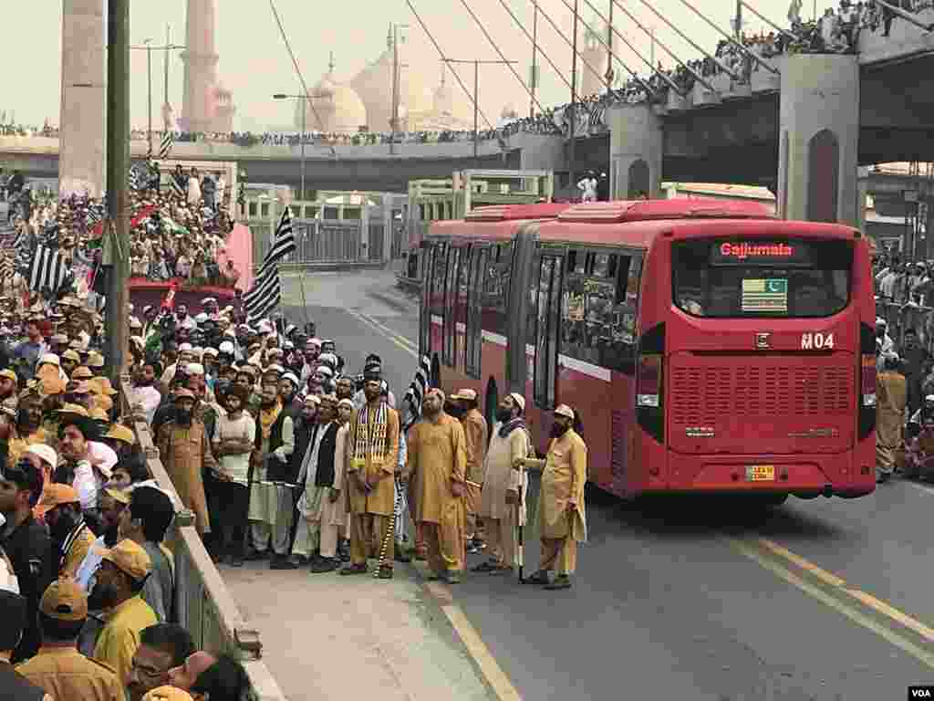 انصار الاسلام کے رضا کار لوگوں کو میٹرو روٹ سے ہٹا رہے ہیں۔